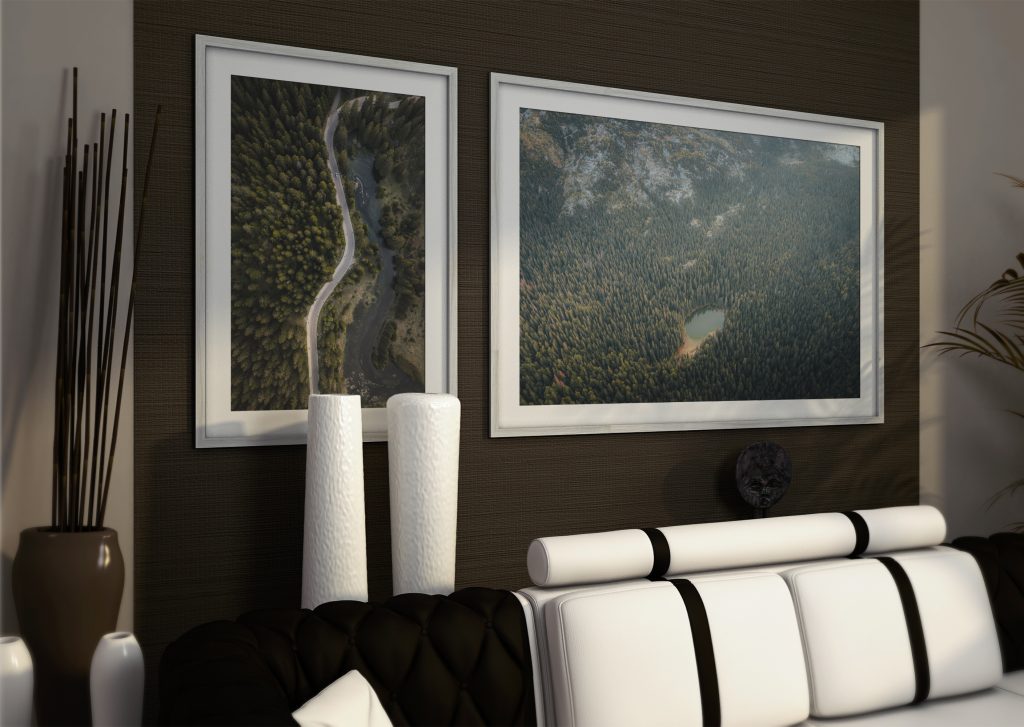 Framed fine art prints above a sofa